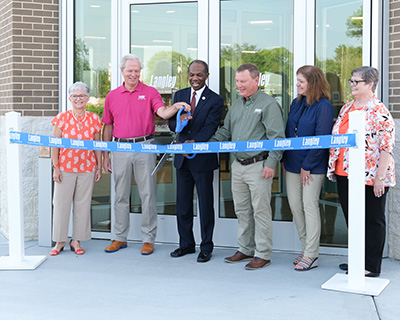 Deb Vollmer, Edward G. "Ted" Henifin, Mayor Tuck, Tom Ryan, Nicole Baker, and Roberta Heywood cut ribbon at grand opening ceremony.